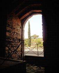 Old ruin building against sky seen through window