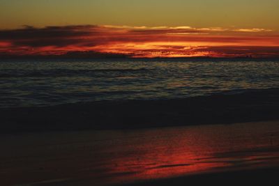 Scenic view of sea against dramatic sky during sunset