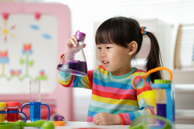 Young girl playing colour sorting and fine motor skill toy at home