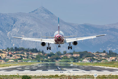 Airplane flying over mountains against clear sky