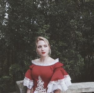 Portrait of a beautiful young woman standing in forest