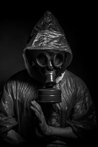 Man wearing gas mask against black background