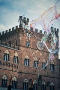 Low angle view of bubbles against buildings in city