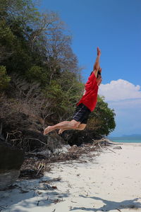 Midsection of person at beach against sky