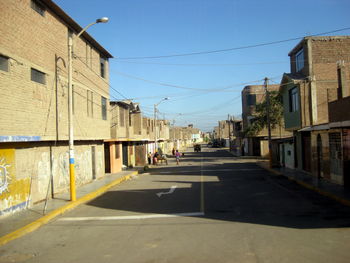 Street amidst buildings against sky in city