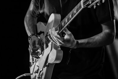 Midsection of man playing guitar