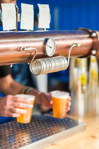 Cropped hands of man serving drinks at restaurant