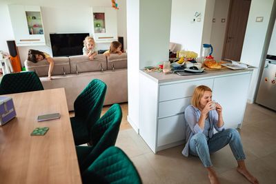Side view of young woman sitting on sofa at home