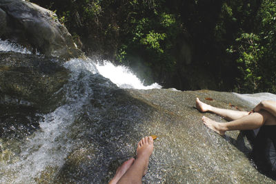 Low section of person standing in water