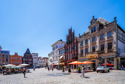 Buildings in city against clear blue sky