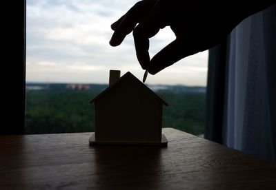 Person holding umbrella on table against window