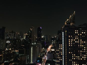 Illuminated buildings in city against sky at night