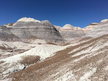 Scenic view of snowcapped mountains against clear blue sky