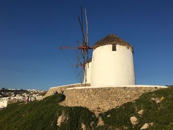 Low angle view of windmill against clear blue sky