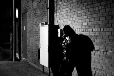 Woman standing outside building at night