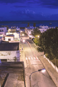 High angle view of road by buildings in city at night