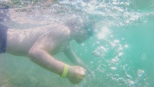 Low section of woman swimming in sea