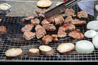 High angle view of meat and vegetable cooking on barbecue grill