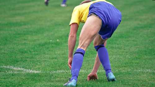 Full length of soccer player playing on field