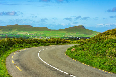 Empty road along landscape against sky