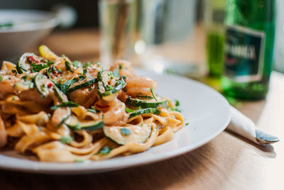 Close-up of tagliatelle pasta with zucchini served in plate on table