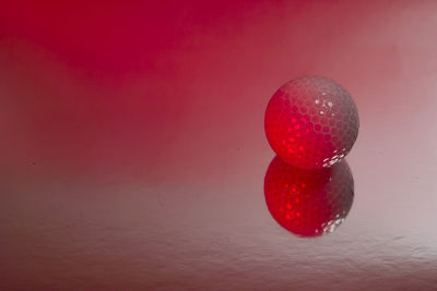 Close-up of red ball against pink background