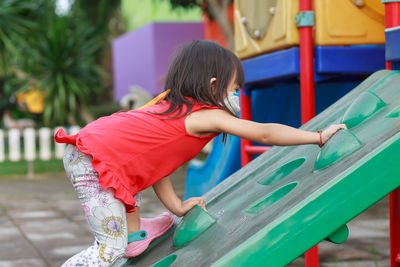 Rear view of girl playing on playground