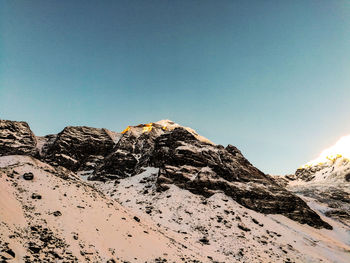 Scenic view of snowcapped mountains against clear blue sky