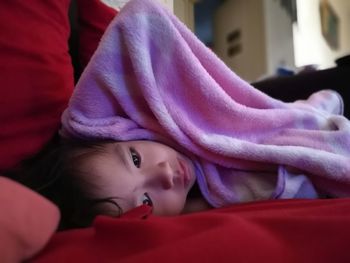 Portrait of girl lying on bed at home