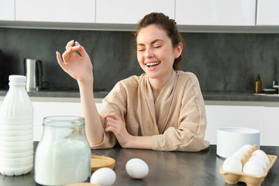 Portrait of young woman having breakfast at home