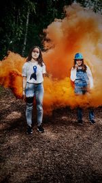 Full length of man standing against orange wall in forest