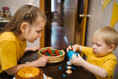 Brother and sister color easter eggs