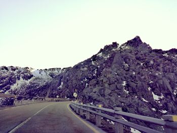 Road by mountain against clear sky