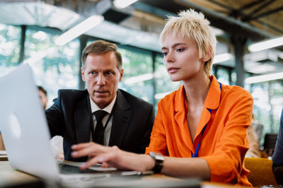 Portrait of young woman using laptop at office