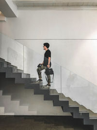 Side view of young man standing on staircase