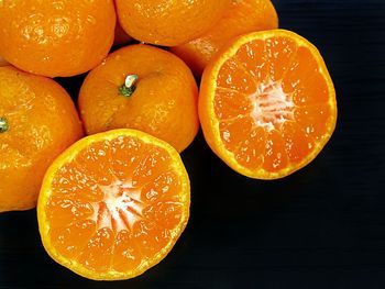 Close-up of oranges on table against black background