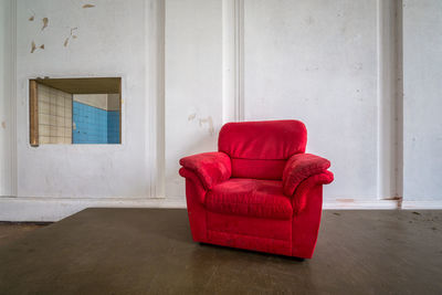 Empty red couch against wall