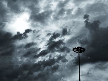 Low angle view of floodlight against cloudy sky