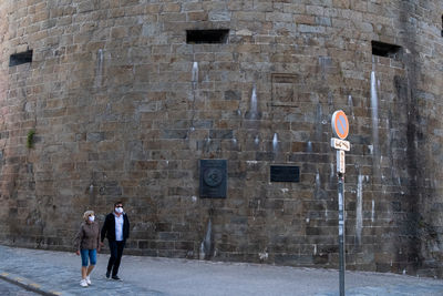 People walking on footpath in city