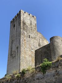 Low angle view of old building castle against blue sky