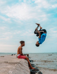 Friends on beach against sky