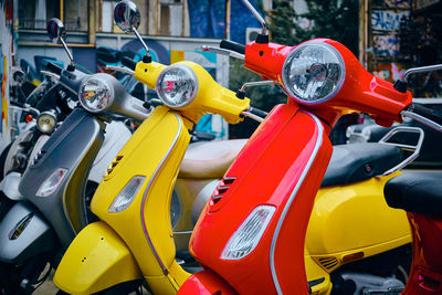 Vintage red, yellow and grey scooter parked in a row. three bright colorful scooters on a parking