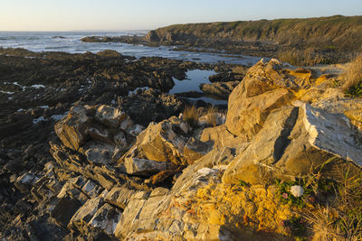 Rocks on beach against sky