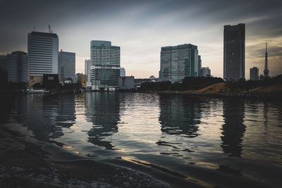 Reflection of city in water against sky