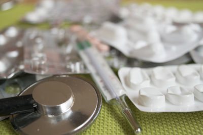 Close-up of stethoscope with thermometer and blister packs