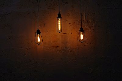 Low angle view of light bulb against wall