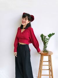 Woman standing by potted plant on table