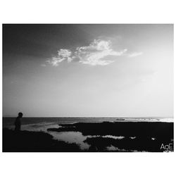 Silhouette man standing on beach against sky