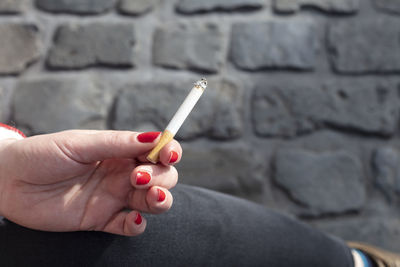 Close-up of hand holding cigarette