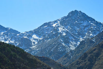 Scenic view of snowcapped mountains against clear blue sky